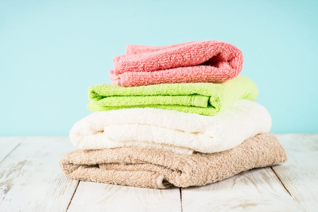 A stack of bathrobes on wooden table