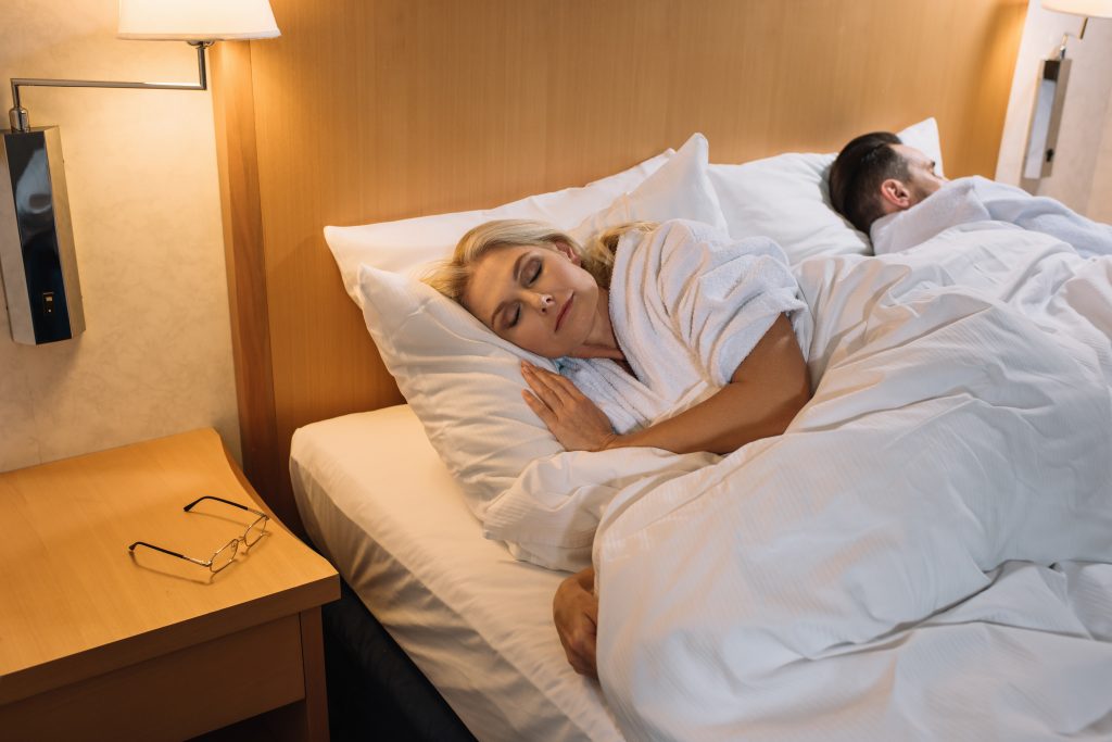 Couple in bathrobes sleeping in bed 