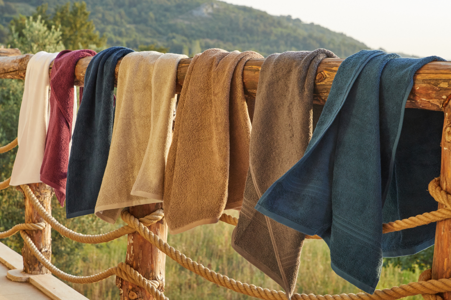 Colorful towels on an exterior wooden railing